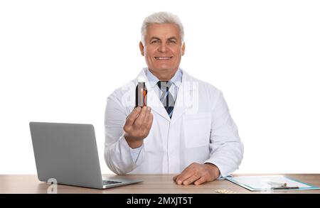 Professioneller Apotheker mit Sirup und Laptop am Tisch vor weißem Hintergrund Stockfoto