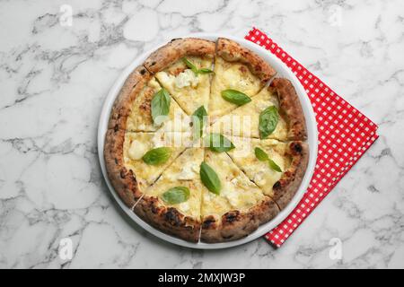 Leckere Käsepizza mit Basilikum auf einem weißen Marmortisch, Blick von oben Stockfoto