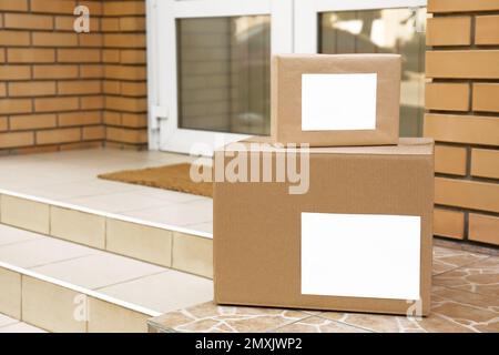 Zustellpakete auf der Veranda nahe der Eingangstür Stockfoto