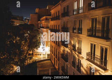 Ein unauffälliger Blick auf die Fassade eines Wohngebäudes in Lissabon in der Nacht mit Metallzäunung und einem Baum auf der linken Seite des i Stockfoto