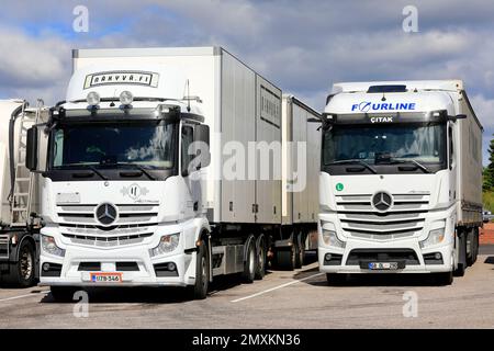 Zwei weiße Mercedes-Benz Actros Lastkraftwagen mit finnischem Anhänger und einem Auflieger mit Truthahnschildern. Salo, Finnland. 30. Juli 2022. Stockfoto