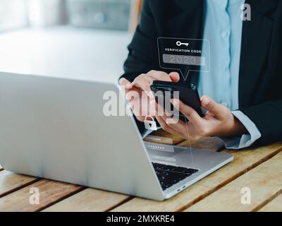 Zwei-Stufen-Authentifizierung (2FA) Konzept. 2023, Bestätigungscode und Schlüsselsymbol auf dem Smartphone während der Verwendung des Computers zur Passwortbestätigung, IDE Stockfoto