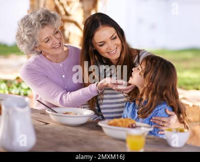 Beim Frühstück eine Beziehung aufbauen. Eine glückliche Familie, die mehrere Generationen miteinander frühstückt. Stockfoto