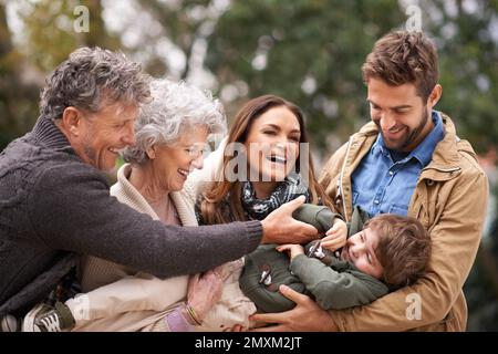 Die besten Dinge im Leben sind keine Dinge. Eine glückliche Familie, die Spaß im Freien hat. Stockfoto