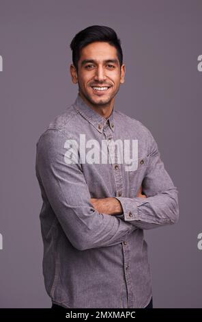 Lockeres Selbstvertrauen. Studioaufnahme eines hübschen jungen Mannes, isoliert auf Grau. Stockfoto