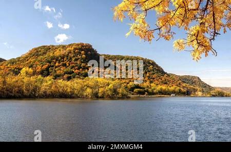 West Lake Winona mit seinen Klippen und Bäumen, die an einem sonnigen Herbsttag in Winona, Minnesota, USA, ihre Herbstfarben zeigen. Stockfoto