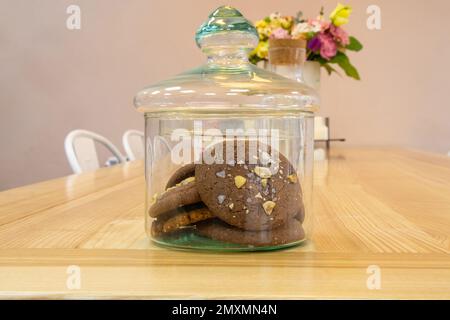 Ein Glas Schokoladenkekse steht auf einem Tisch Stockfoto