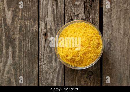 Roher Vermicelli auf einem Teller steht auf einem Tisch Stockfoto