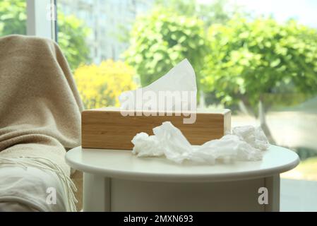 Gebrauchte Papiertücher und Holzhalter auf weißem Tisch Stockfoto