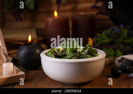 Zusammensetzung mit Mörtel, Heilkräutern und Edelsteinen auf Holztisch Stockfoto