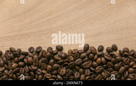 Kaffeebohnen auf Holzhintergrund mit Kopierbereich. Stockfoto