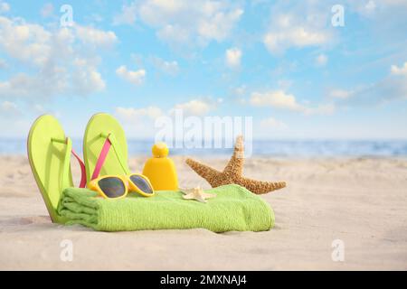 Verschiedene stilvolle Strandobjekte und Seesterne auf Sand nahe dem Meer Stockfoto