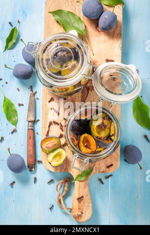 Hausgemachte und gesunde eingelegte Pflaumen in einem Glas mit Gewürzen. Konservierte Früchte für den Winter. Stockfoto