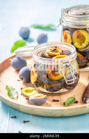 Süße und leckere eingelegte Pflaumen in einem Glas mit Gewürzen. Eingelegtes Obst der Saison für den Winter. Stockfoto