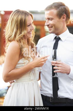 Liebe, Wein und Paar auf einer Party, Lächeln und glücklich beim Reden, Flirten und Binden auf einer Outdoor-Veranstaltung. Champagner, Romantik und Mann mit Frau drin Stockfoto