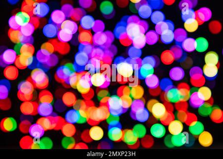 Mehrfarbige Kreise aus farbigen Glühbirnen Girlanden mit Bokeh-Effekt auf schwarzem Hintergrund Stockfoto