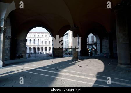 Italien, Bergamo, Blick durch die Torbögen des Palazzo della Ragione (Ragione-Palast) über die Piazza Vecchia in Richtung Biblioteca Civica 'Ange Stockfoto