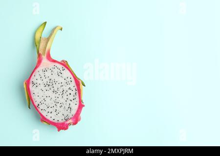 Die Hälfte der köstlichen Drachenfrucht (Pitahaya) auf hellblauem Hintergrund, Draufsicht. Platz für Text Stockfoto