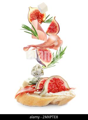 Leckeres Bruschetta mit fliegenden Zutaten auf weißem Hintergrund Stockfoto