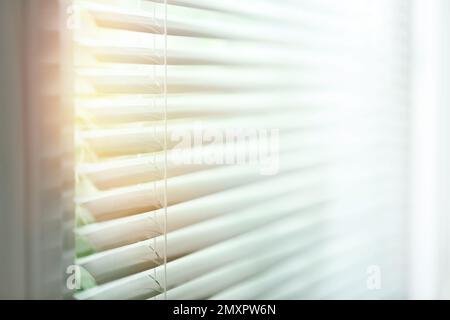 Fenster mit Jalousien an sonnigen Tagen, geschlossen Stockfoto