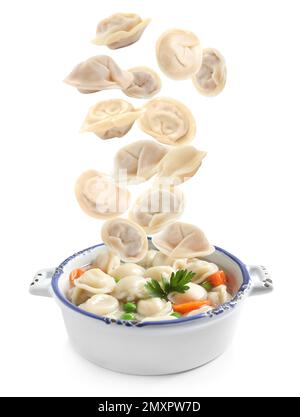 Viele leckere Knödel fallen auf weißem Hintergrund in die Schüssel Stockfoto