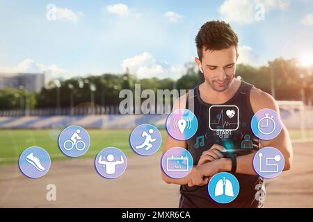 Mann, der beim Training im Freien eine Smartwatch verwendet. Symbole in der Nähe des Geräts Stockfoto