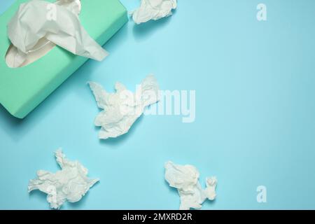 Gebrauchte Papiertücher und Schachtel auf hellblauem Hintergrund, flach liegend. Platz für Text Stockfoto