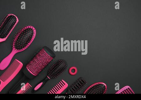 Flache Laienzusammensetzung mit modernen Kämmen und Bürsten auf schwarzem Hintergrund Stockfoto