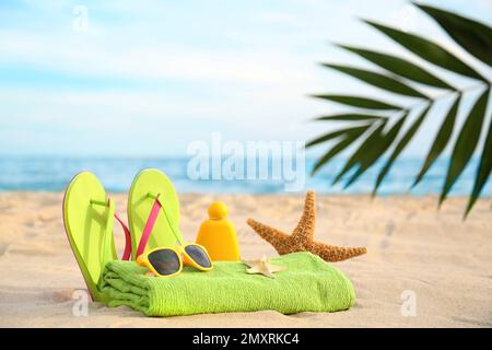 Verschiedene stilvolle Strandobjekte und Seesterne auf Sand nahe dem Meer Stockfoto