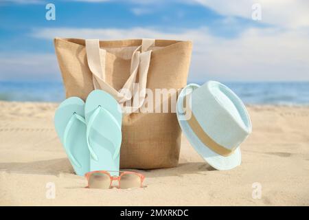 Verschiedene stilvolle Strandobjekte auf Sand in der Nähe des Meeres Stockfoto