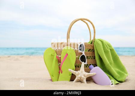 Verschiedene stilvolle Strandobjekte und Seesterne auf Sand nahe dem Meer Stockfoto