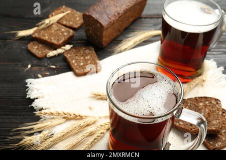 Tassen mit köstlichem KWass, Stacheln und Brot auf dem Tisch Stockfoto
