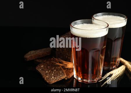 Köstlicher Kavass, Brot und Stacheln auf schwarzem Hintergrund Stockfoto