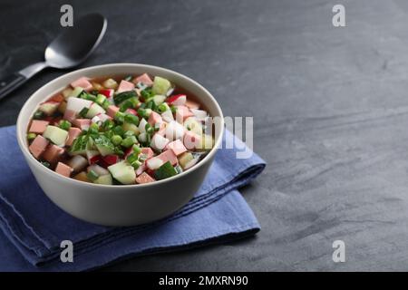 Köstliche kalte Okroshka mit Kvass serviert auf schwarzem Tisch, Platz für Text. Traditionelle russische Sommersuppe Stockfoto