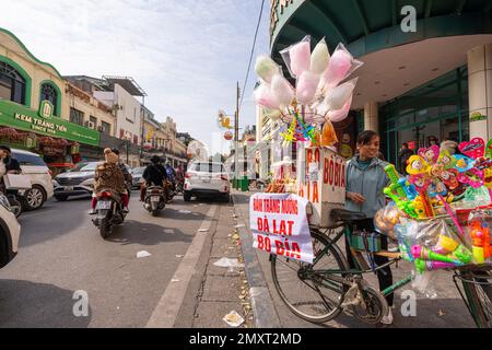 Hanoi, Vietnam, Januar 2023. Der Verkäufer von Süßigkeiten und Zuckerwatte auf einer Straße im Stadtzentrum Stockfoto