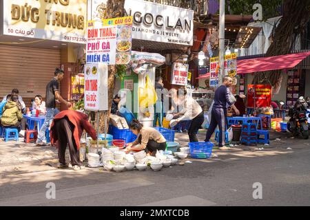 Hanoi, Vietnam, Januar 2023. Geschirr spülen auf der Straße eines kleinen Restaurants im Stadtzentrum Stockfoto