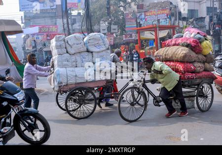 INDIEN. UTTARPRADESH. WARENTRANSPORT VARANASI (BENARES) DURCH RICK SHAW Stockfoto