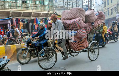 INDIEN. UTTARPRADESH. WARENTRANSPORT VARANASI (BENARES) DURCH RICK SHAW Stockfoto