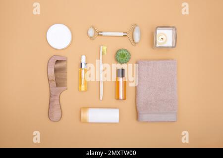 Flache Verlegung von Kosmetik- und Hygieneartikeln auf orangefarbenem Hintergrund. Selbstpflegekonzept. Blick von oben. Stockfoto