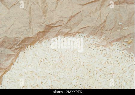Hintergrund der Reiskörner auf zerknittertem altem Pergamentverpackungspapier Stockfoto
