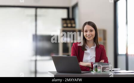 Asiatische Geschäftsfrau, die einen Deal macht, ein Haus oder eine Wohnung im Büro zu kaufen, Hausversicherungs-Konzept Stockfoto