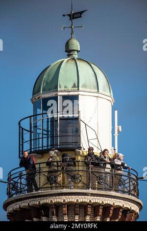 04. Februar 2023, Mecklenburg-Vorpommern, Warnemünde: Tagesbesucher stehen auf der Aussichtsplattform vom Leuchtturm in Warnemünde unter blauem Himmel und Sonnenschein. Die Winterferien beginnen an diesem Wochenende in Mecklenburg-Vorpommern. Foto: Frank Hormann/dpa Stockfoto