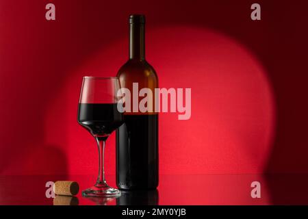 Flasche Rotwein mit Weinglas und Kork auf dem Tisch. Ansicht mit Platz für Ihren Text. Stockfoto