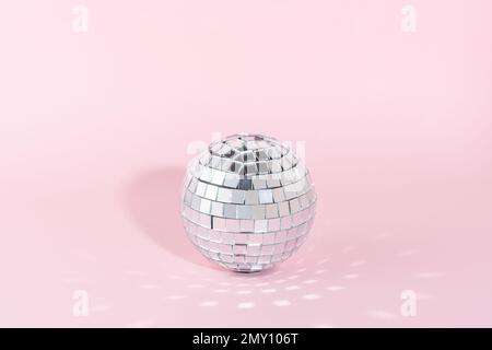 Glänzender Discoball auf pinkfarbenem Hintergrund. Minimales Partykonzept. Stockfoto