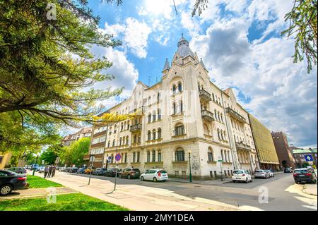 Vorderansicht der Fassade des wunderschönen alten Gebäudes mit alten Skulpturen im Stadtzentrum von Szeged, Ungarn Stockfoto