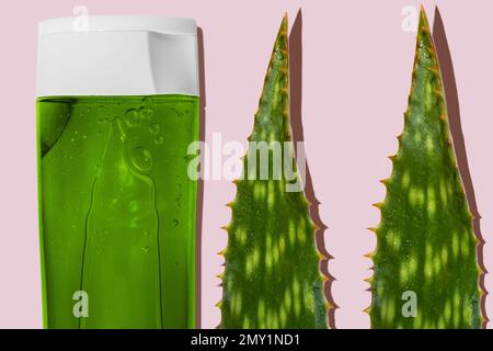 Grünes Aloe-Gel in einer transparenten Flasche auf pinkfarbenem Hintergrund. Aloe geht auf pinkfarbenem Hintergrund. aloe Vera Kosmetikset Stockfoto