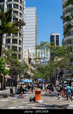 Blick auf die Straße Uruguaiana und die nahegelegenen Gebäude nahe der Kreuzung mit der Straße Sete de Setembro im besiedelten Viertel Centro unter blauem Himmel. Stockfoto