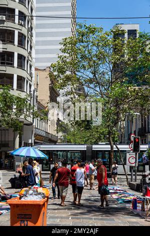 Blick auf die überfüllte Uruguaiana Straße und die nahegelegenen Gebäude nahe der Kreuzung mit der Sete de Setembro Straße im Centro Viertel unter blauem Sommerhimmel. Stockfoto