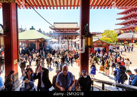 Tokio, Schrein und Sensoji-Tempel in Asakusa. Touristen füllen den Hof vor und auf die Schritte der Haupthalle mit den Hozomon Tor hinter. Blue Sky Stockfoto