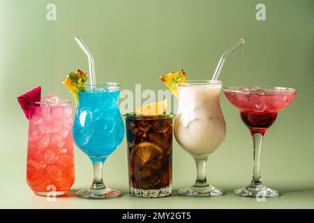 Im Sommer werden klassische tropische alkoholische Cocktails auf grünem Hintergrund serviert Stockfoto